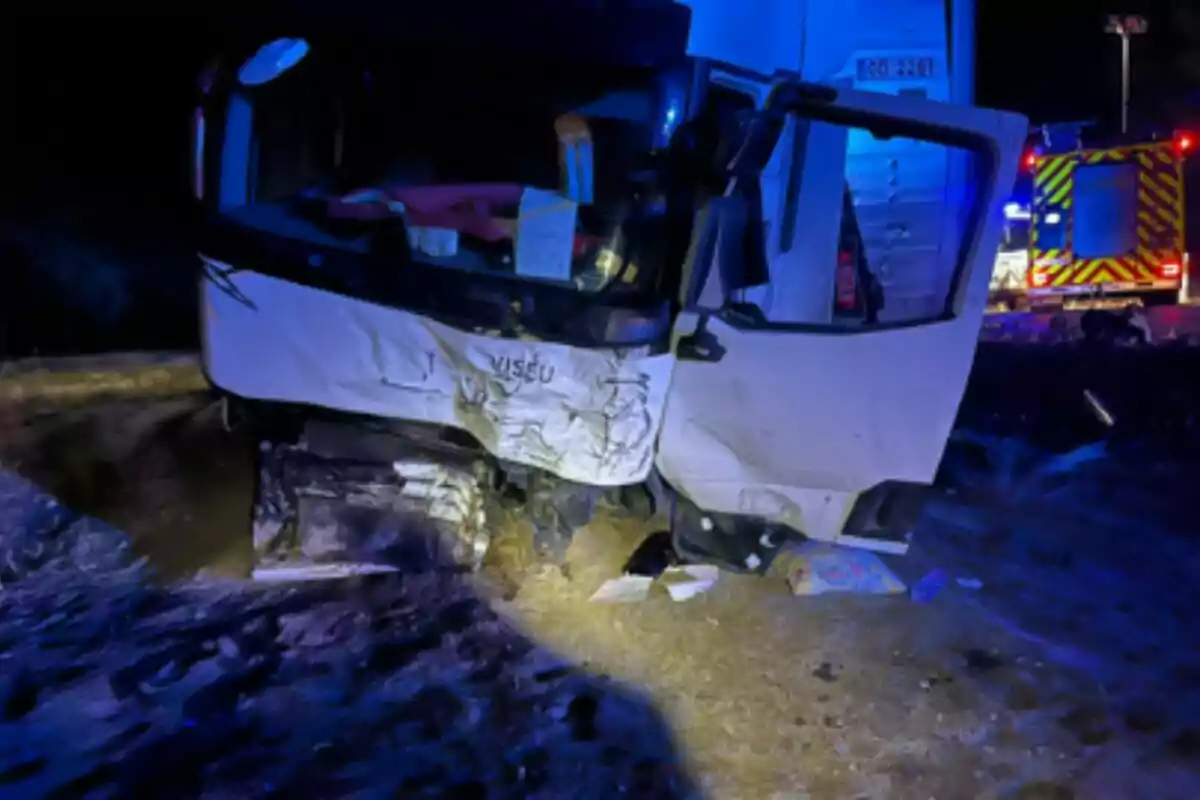 Camió blanc amb la cabina greument danyada després d’un accident a la carretera durant la nit a Traspinedo (Valladolid), amb llums d’emergència i un vehicle de rescat al fons.