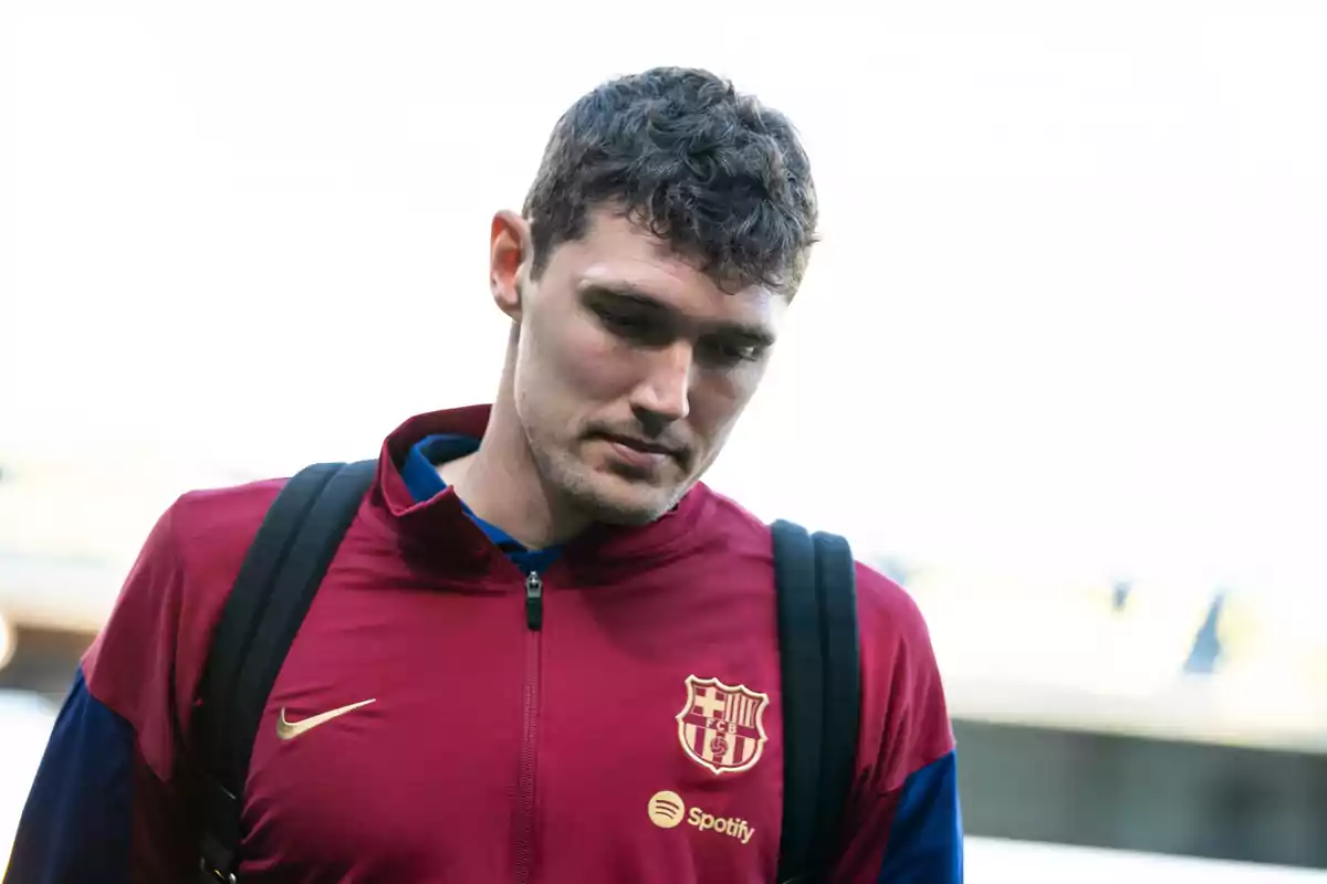 Christensen vestint una jaqueta de l’equip i portant una motxilla