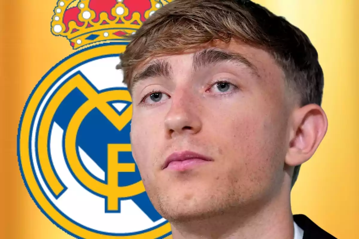 Jove de cabell curt i ros amb expressió seriosa davant l’escut del Reial Madrid sobre fons daurat