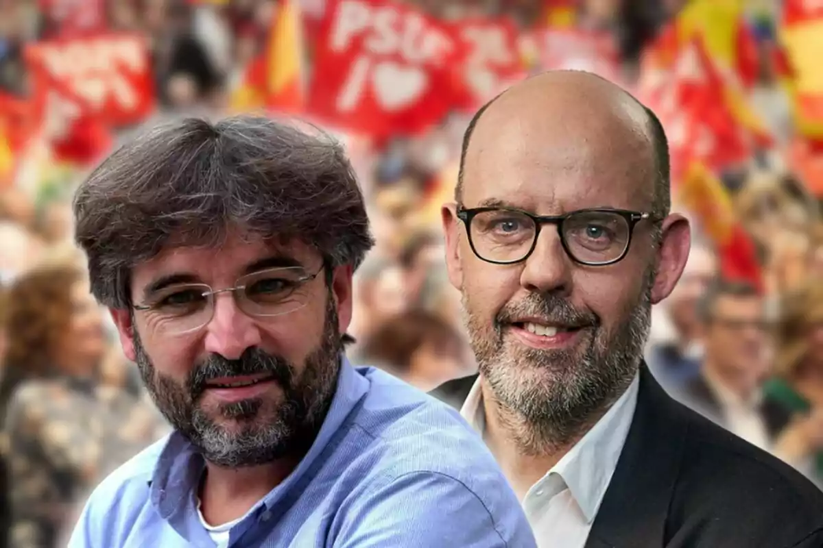 Dos homes amb ulleres posen davant d’un fons desenfocat de persones i banderes vermelles en una manifestació