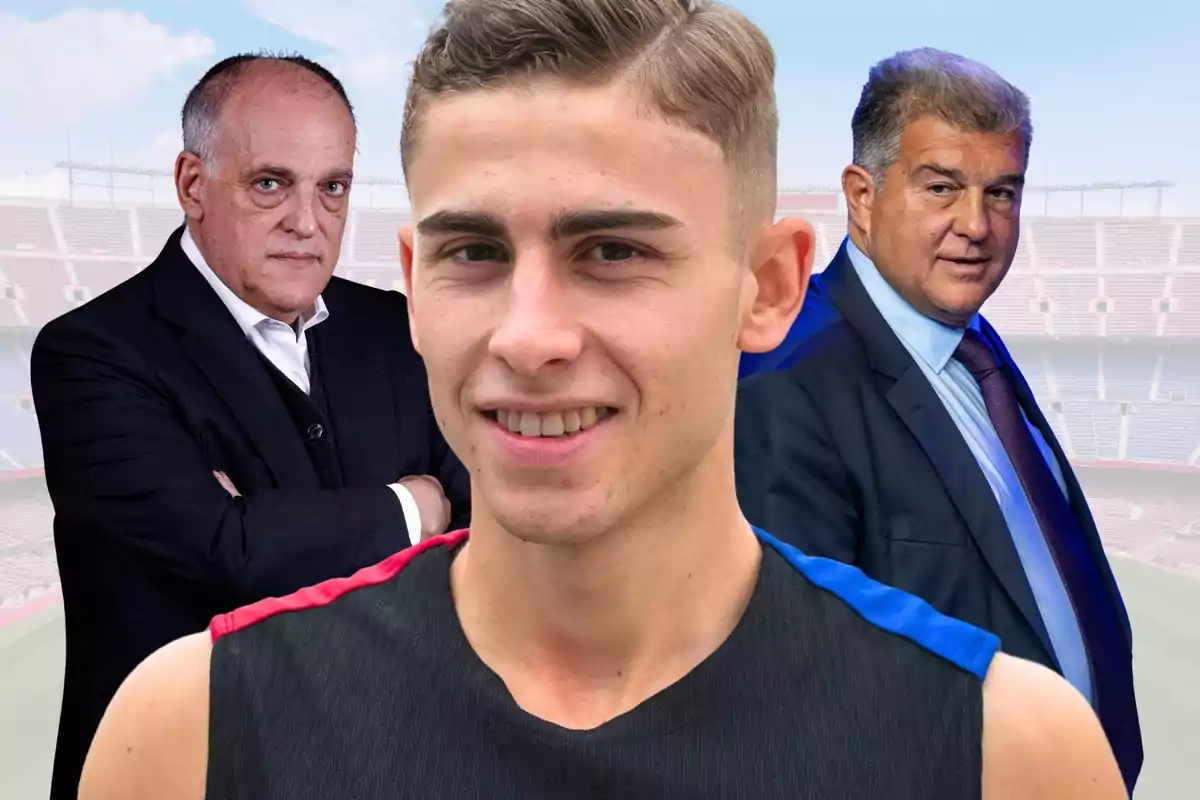 Un jove futbolista somriu en primer pla mentre dos homes més grans amb vestit posen darrere d’ell en un estadi de futbol.