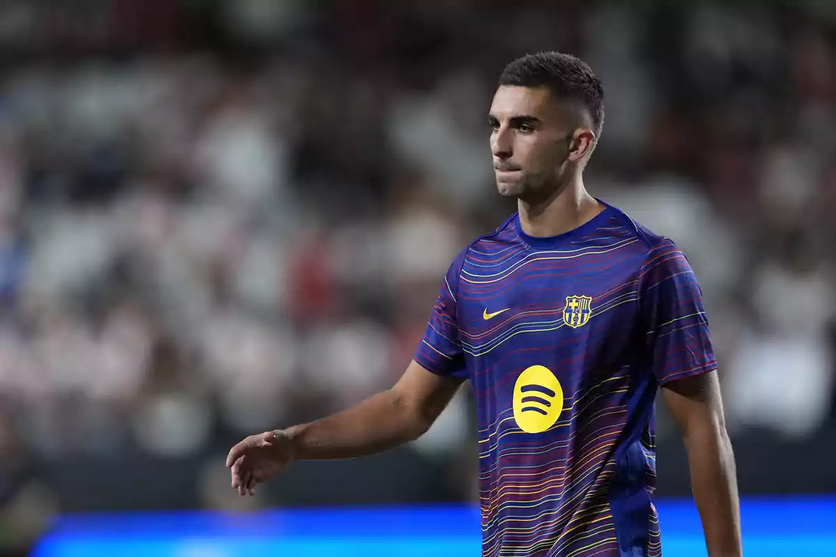 Ferran Torres amb samarreta d’escalfament blava amb línies de colors i el logotip de Spotify al centre durant un partit