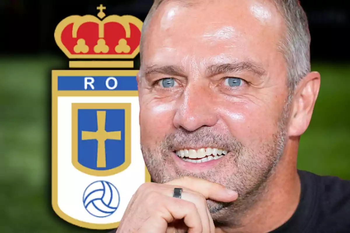 Home somrient en primer pla amb l’escut del Real Oviedo de fons