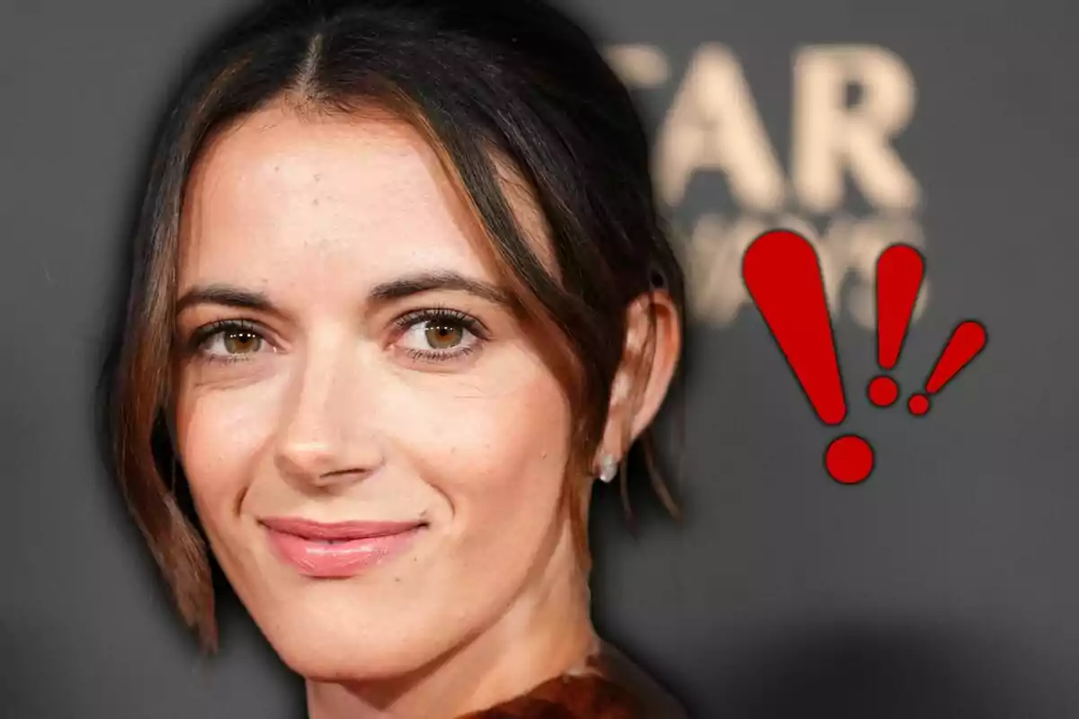 Dona de cabells foscos amb expressió serena i un símbol d’exclamació vermell al seu costat sobre un fons fosc