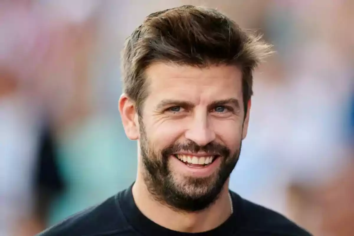 Gerard Piqué amb barba i cabells castanys somriu mirant a la càmera amb un fons desenfocat Gerard Piqué amb barba i cabells castanys somriu mirant a la càmera amb un fons desenfocat