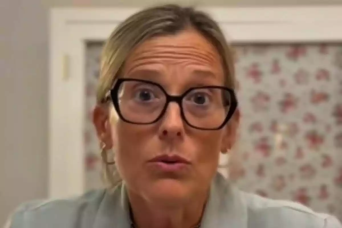 Berta Lamas amb els cabells rossos recollits i ulleres grans de pasta negra mirant al davant amb una expressió de sorpresa.