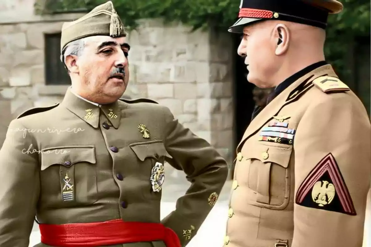 Dos homes amb uniformes militars conversen a l’aire lliure davant d’un edifici de pedra.