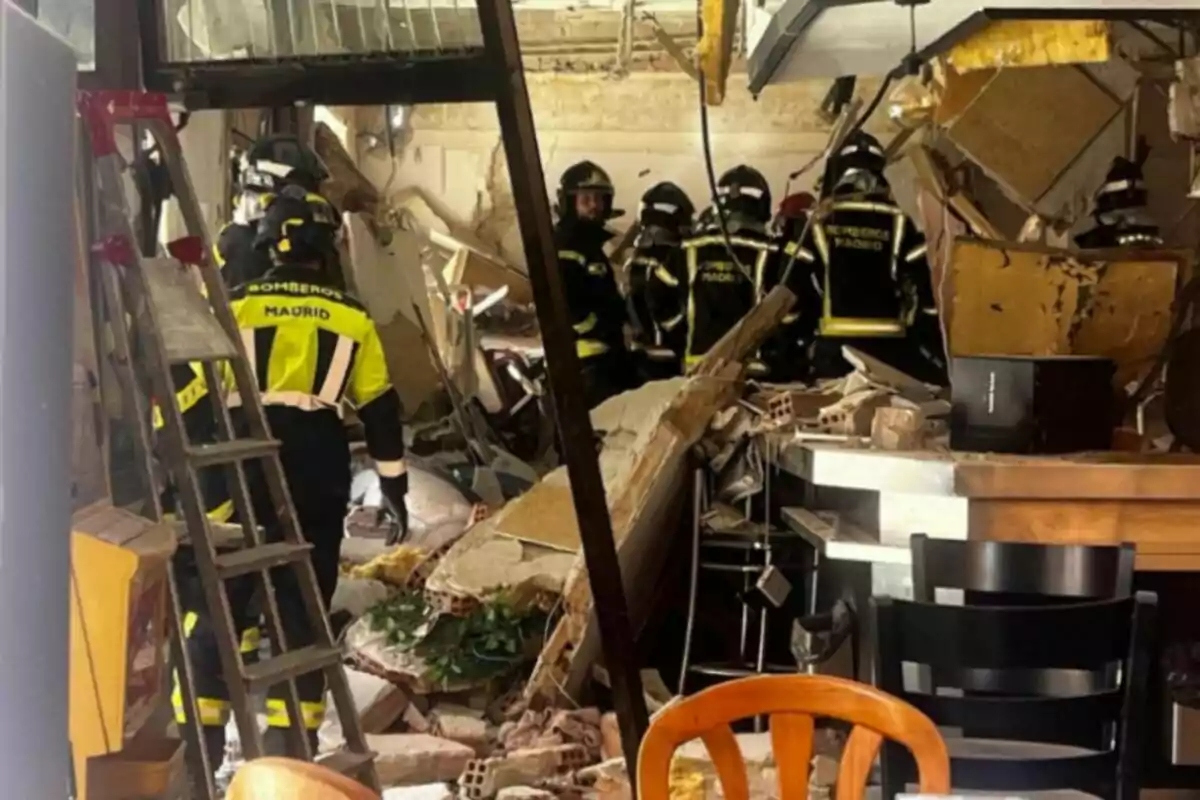 Bomberos de Madrid trabajan entre escombros dentro de un edificio colapsado mientras inspeccionan los daños y buscan posibles víctimas