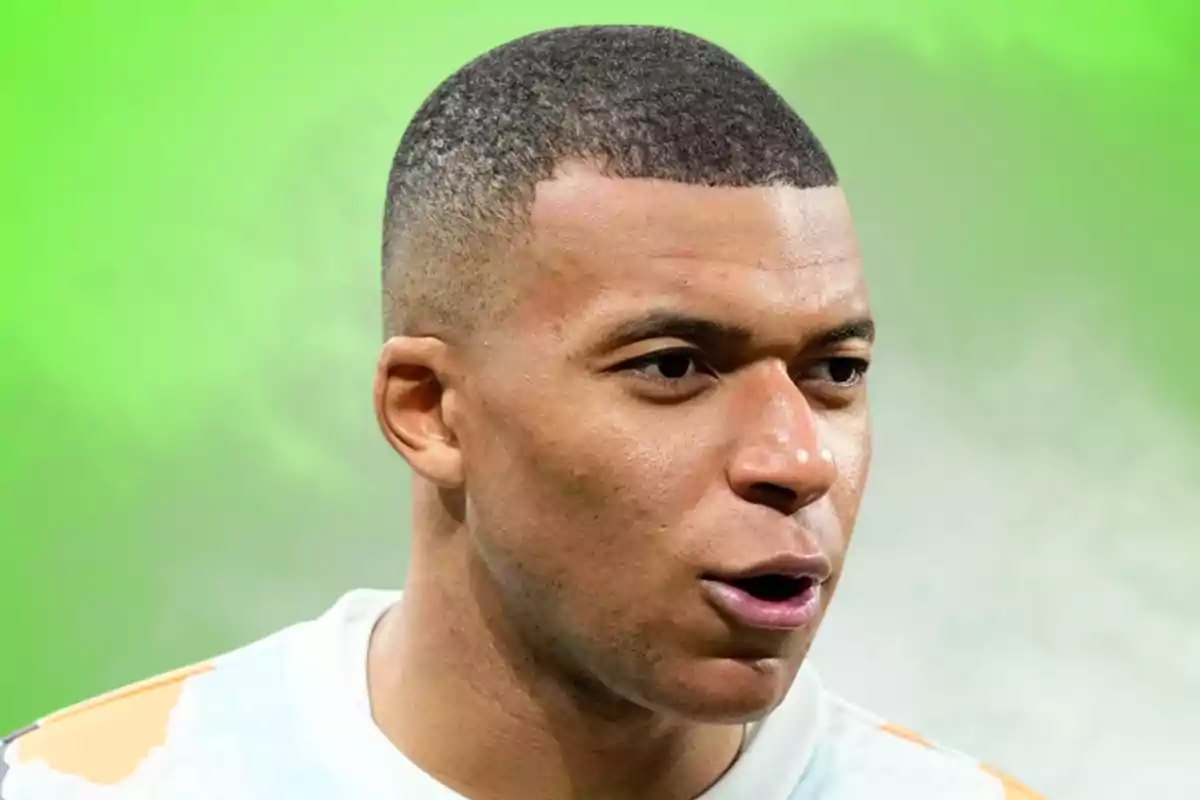 Primer pla d’un home jove amb els cabells curts i expressió seriosa sobre un fons verd difuminat