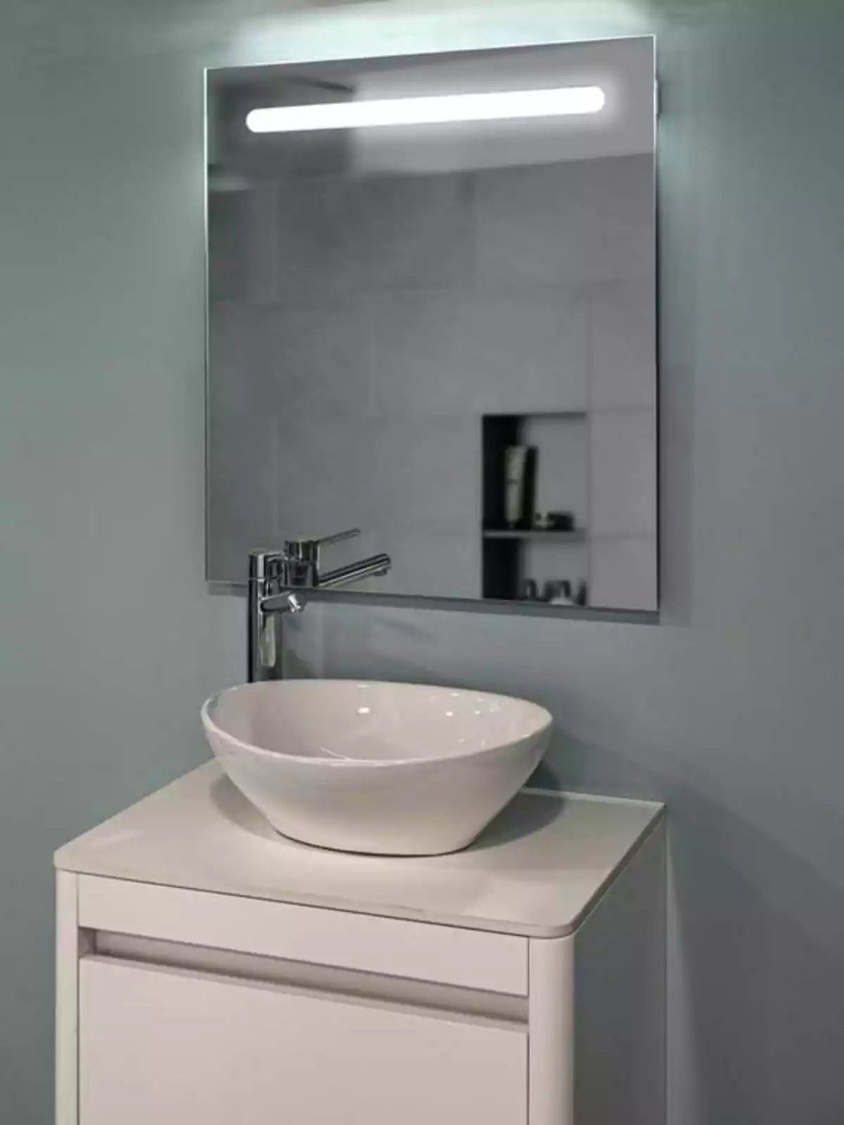 Moble de bany blanc amb lavabo de ceràmica i mirall il·luminat a la paret