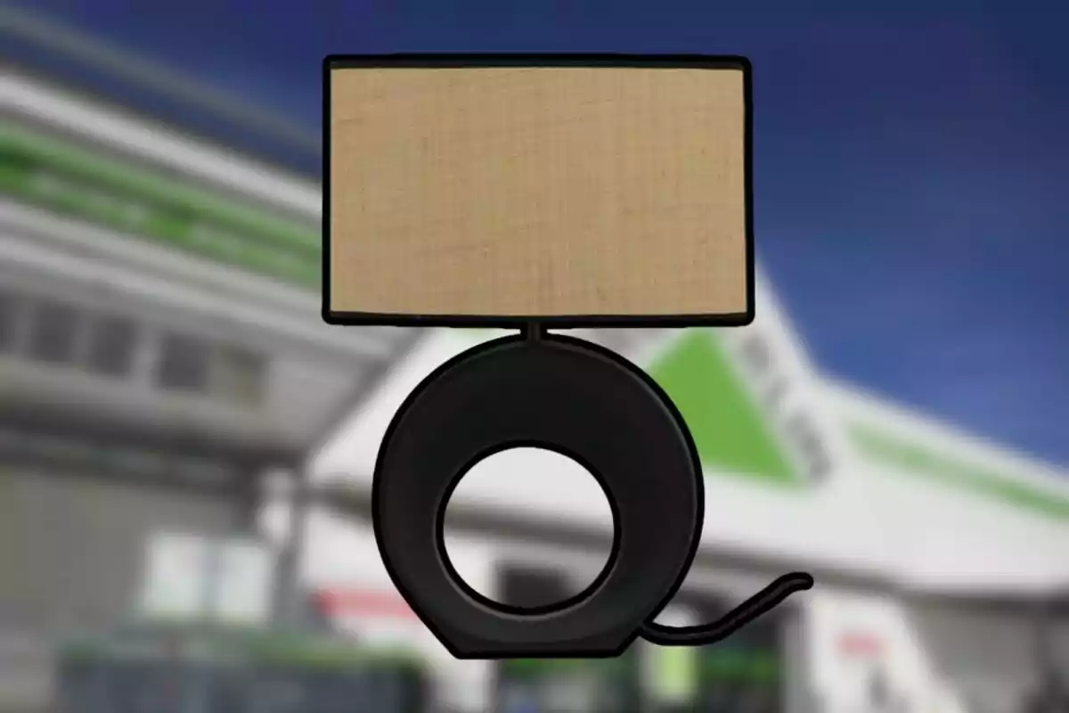 Lámpara de mesa con base circular negra y pantalla rectangular beige frente a un fondo desenfocado de edificio. Lámpara de mesa con base circular negra y pantalla rectangular beige frente a un fondo desenfocado de edificio.