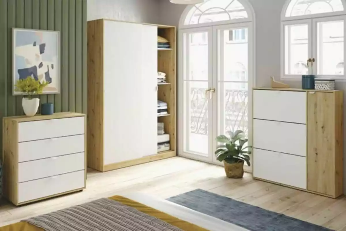 Dormitorio moderno con muebles de madera clara y blanco, grandes ventanas, una planta en maceta y decoración minimalista