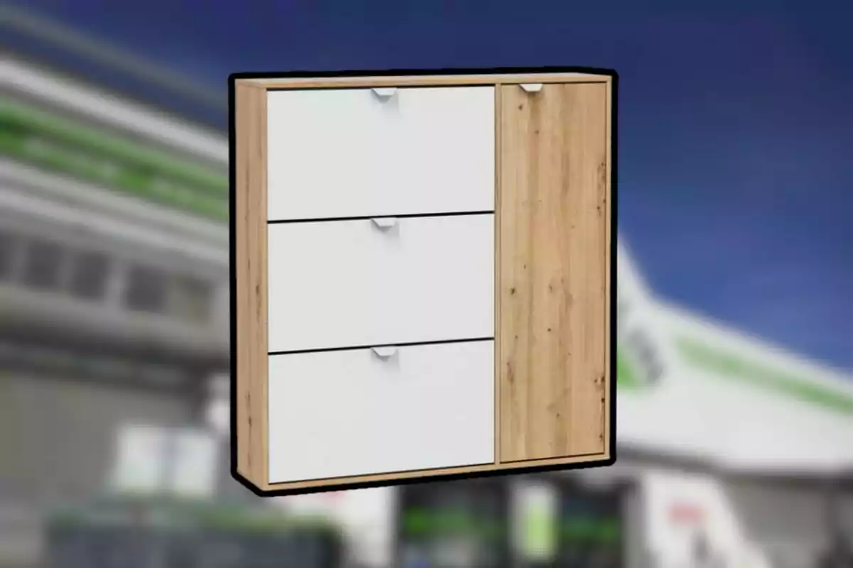 Mueble organizador de madera con tres cajones blancos y una puerta vertical al lado derecho sobre un fondo desenfocado.