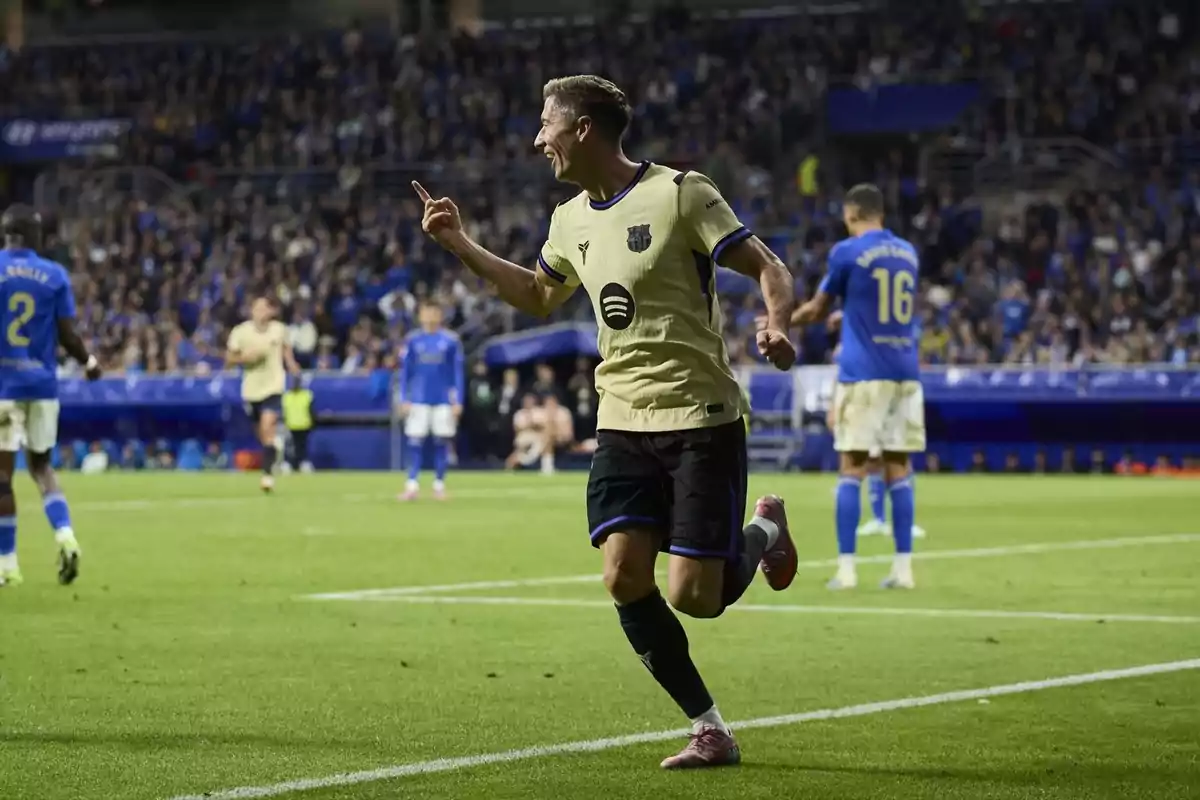Futbolista celebrant un gol en un estadi ple durant un partit entre equips amb uniformes blaus i grocs