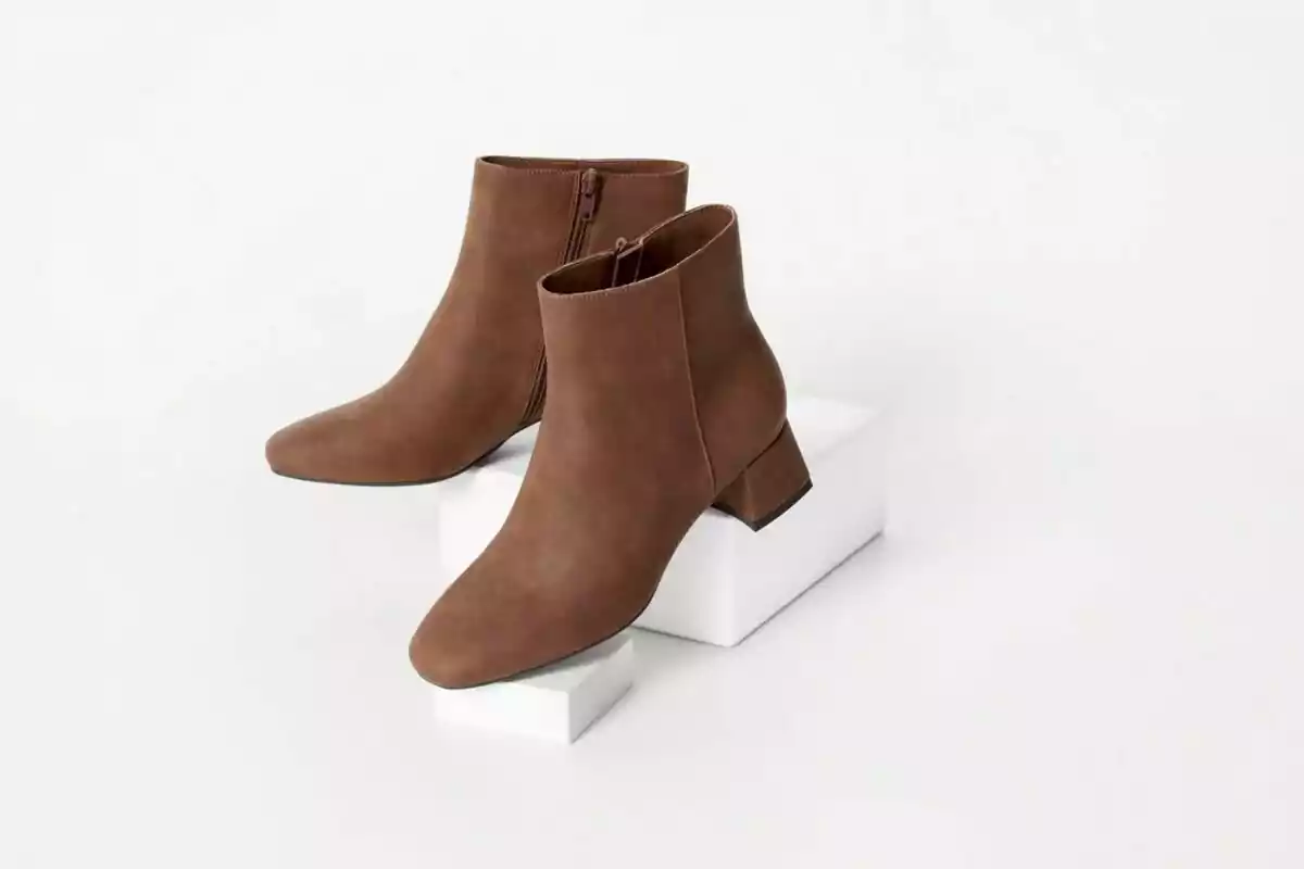 Low-heeled brown ankle boots with side zipper on a white background Low-heeled brown ankle boots with side zipper on a white background