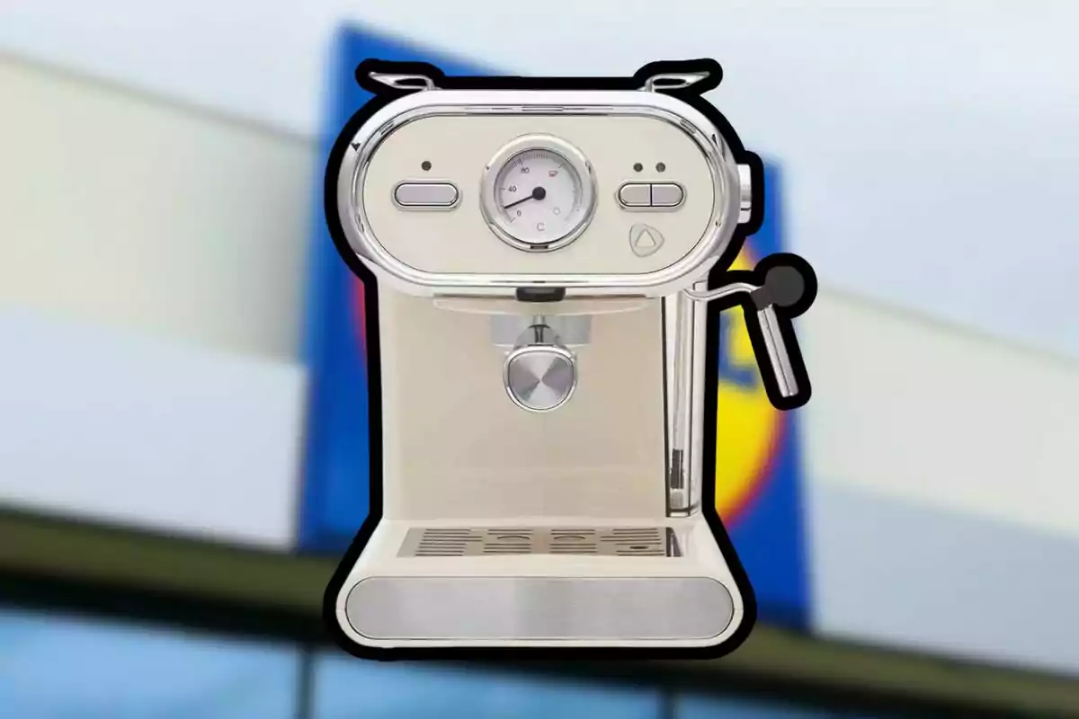 Cafetera de color crema con detalles plateados sobre un fondo desenfocado de una tienda Cafetera de color crema con detalles plateados sobre un fondo desenfocado de una tienda