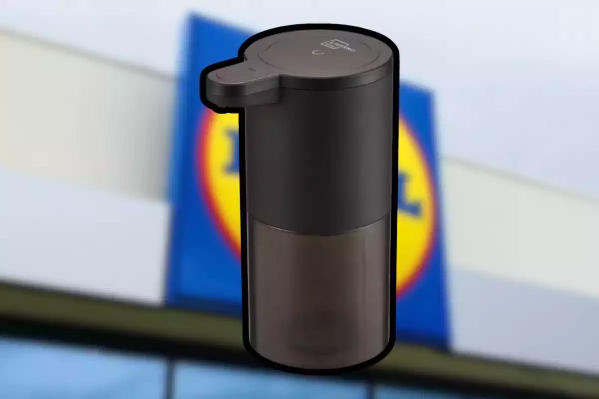 Black automatic soap dispenser with a blurred supermarket sign in the background. Black automatic soap dispenser with a blurred supermarket sign in the background.