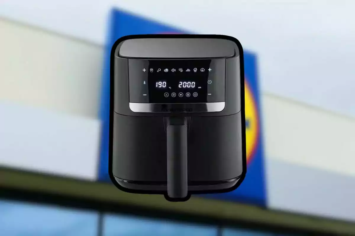 Fregidora d’aire negra amb pantalla digital davant d’un rètol borros de supermercat