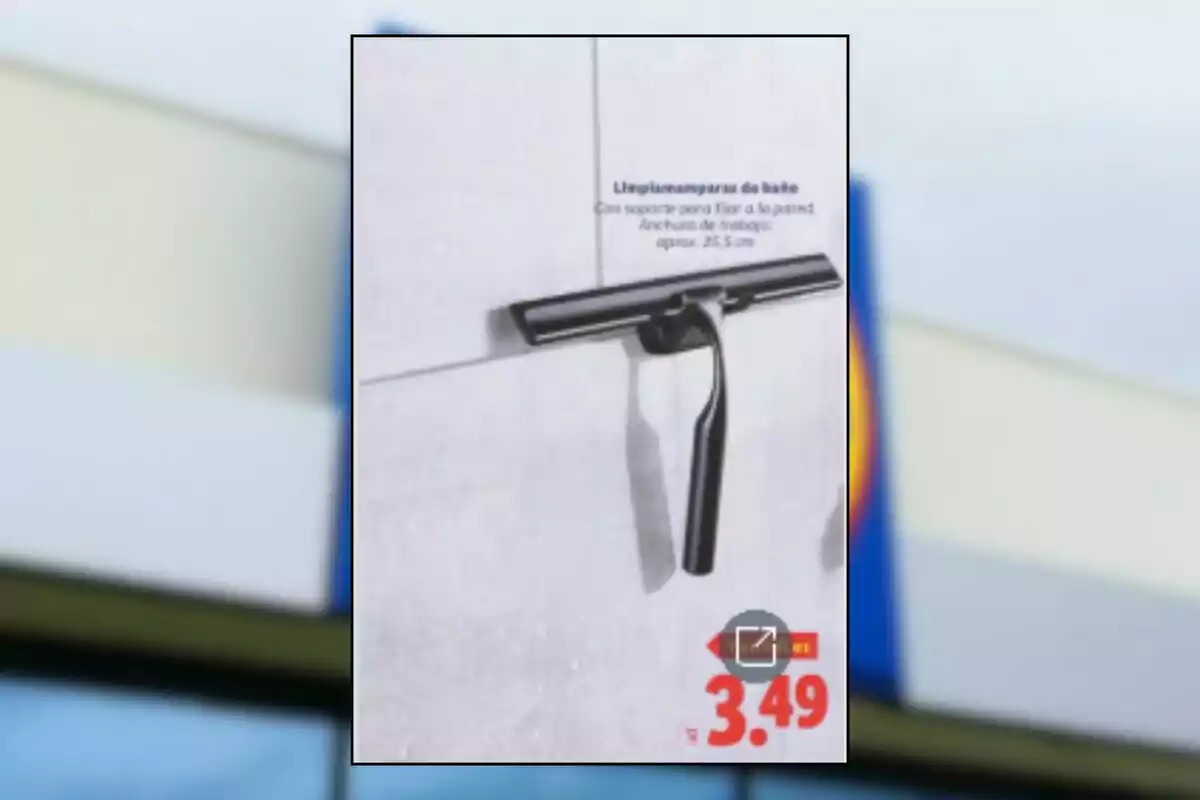 Limpia mamparas de baño negro colgado en una pared de azulejos con precio de 3.49 euros Limpia mamparas de baño negro colgado en una pared de azulejos con precio de 3.49 euros