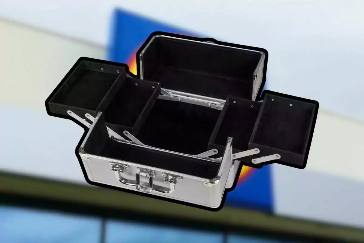 Maletín de aluminio abierto con varios compartimentos vacíos y fondo desenfocado