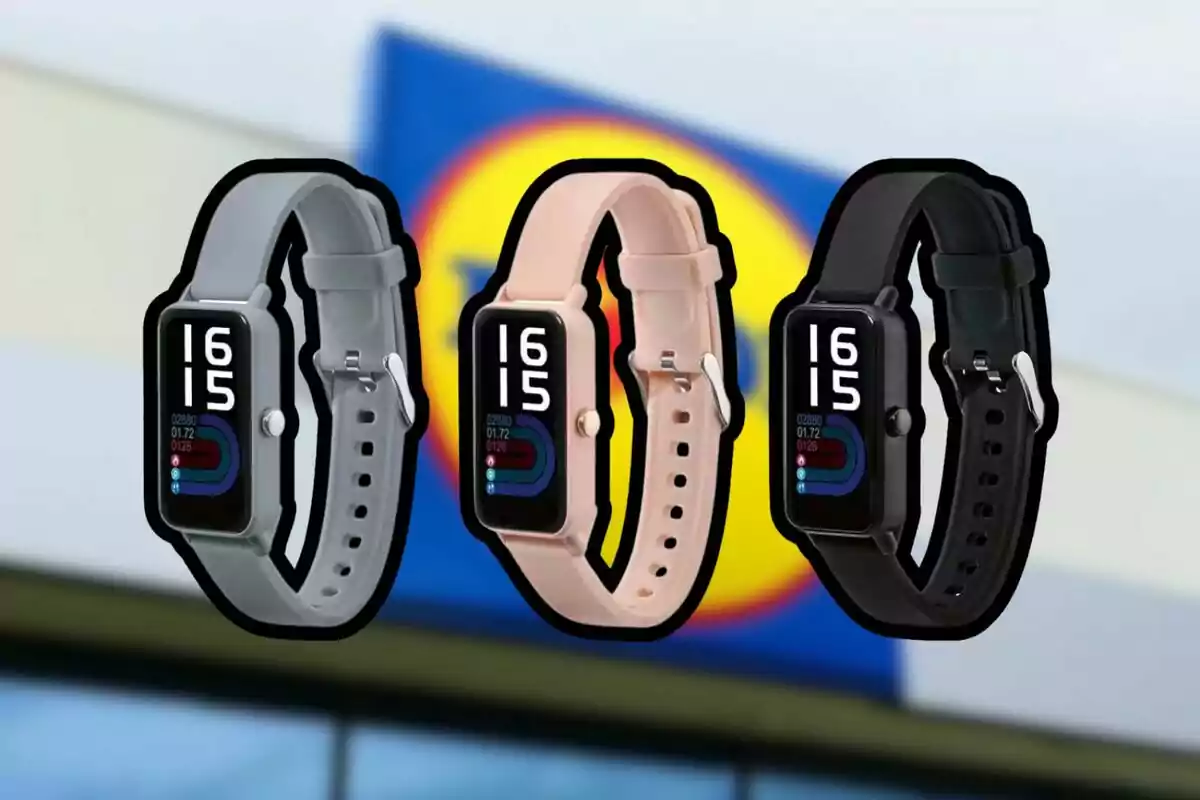 Three smartwatches in gray, pink, and black with their screens on and a blurred supermarket sign in the background