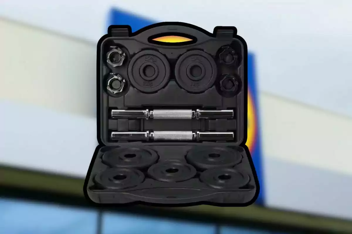 Maletín negro abierto con un set de pesas y mancuernas frente a un fondo desenfocado