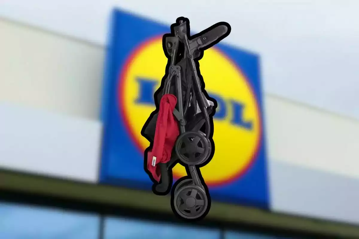 Cochecito plegable de color negro y rojo frente a la fachada de una tienda con el logo de Lidl desenfocado.