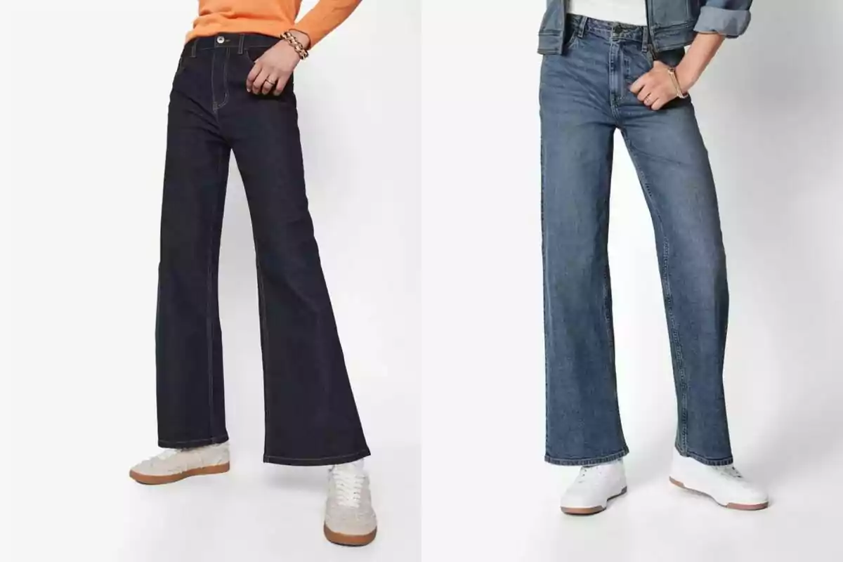 Two women wearing wide-leg denim jeans and white sneakers, one with an orange sweater and the other with a denim jacket