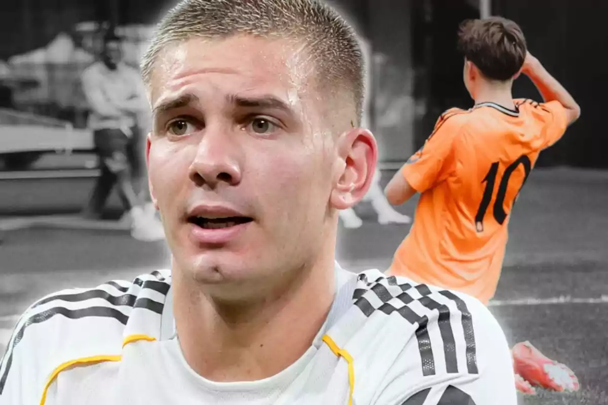 Un futbolista amb samarreta blanca apareix en primer pla mentre al fons es veu un jove amb samarreta taronja i el número 10, en un camp de futbol.