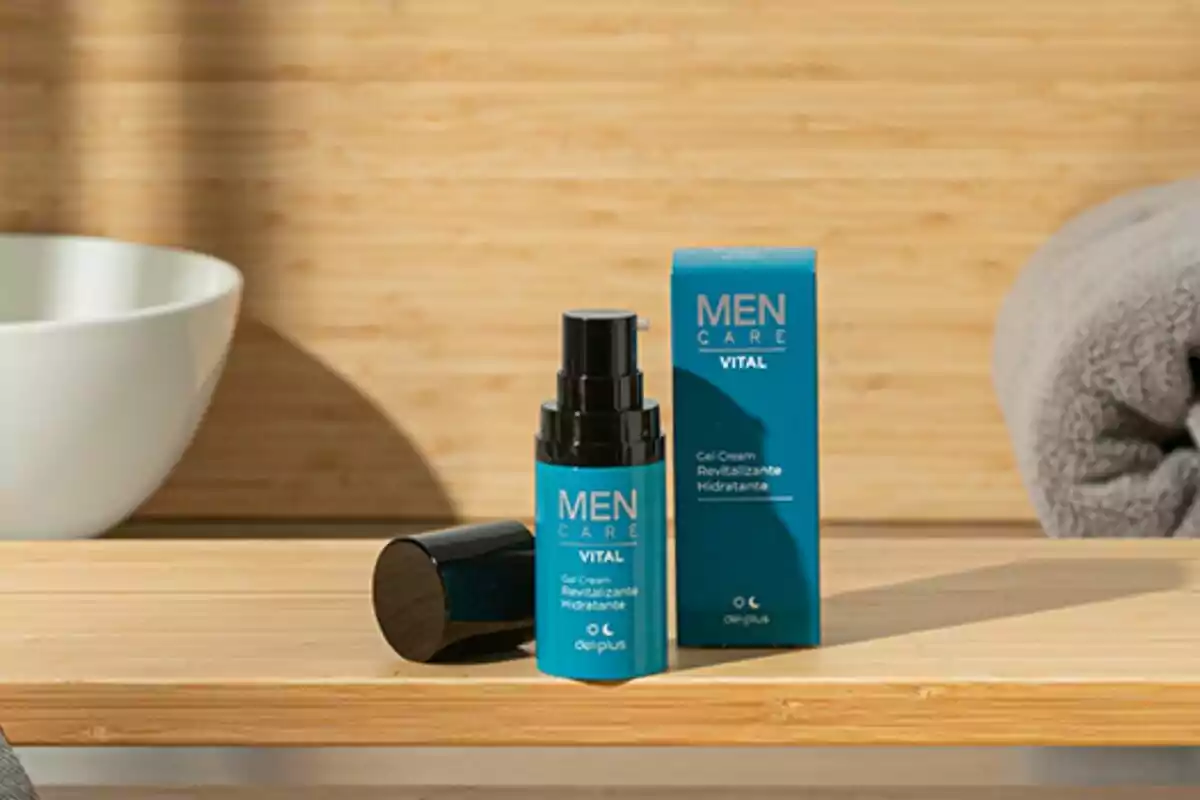 Envase y caja de crema hidratante para hombre sobre una superficie de madera junto a una toalla gris y un lavabo blanco. Envase y caja de crema hidratante para hombre sobre una superficie de madera junto a una toalla gris y un lavabo blanco.