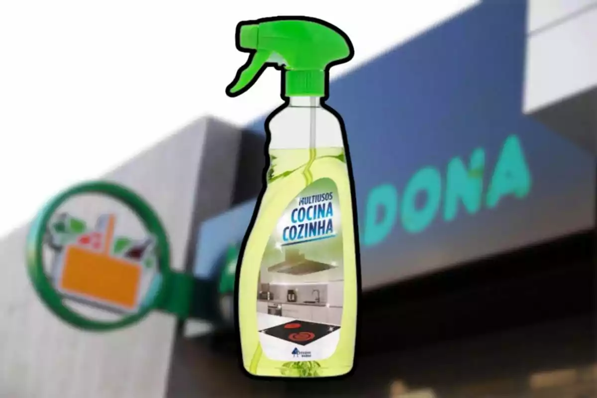 Ampolla de netejador multiús per a cuina amb tap verd davant d’una botiga de supermercat desenfocada