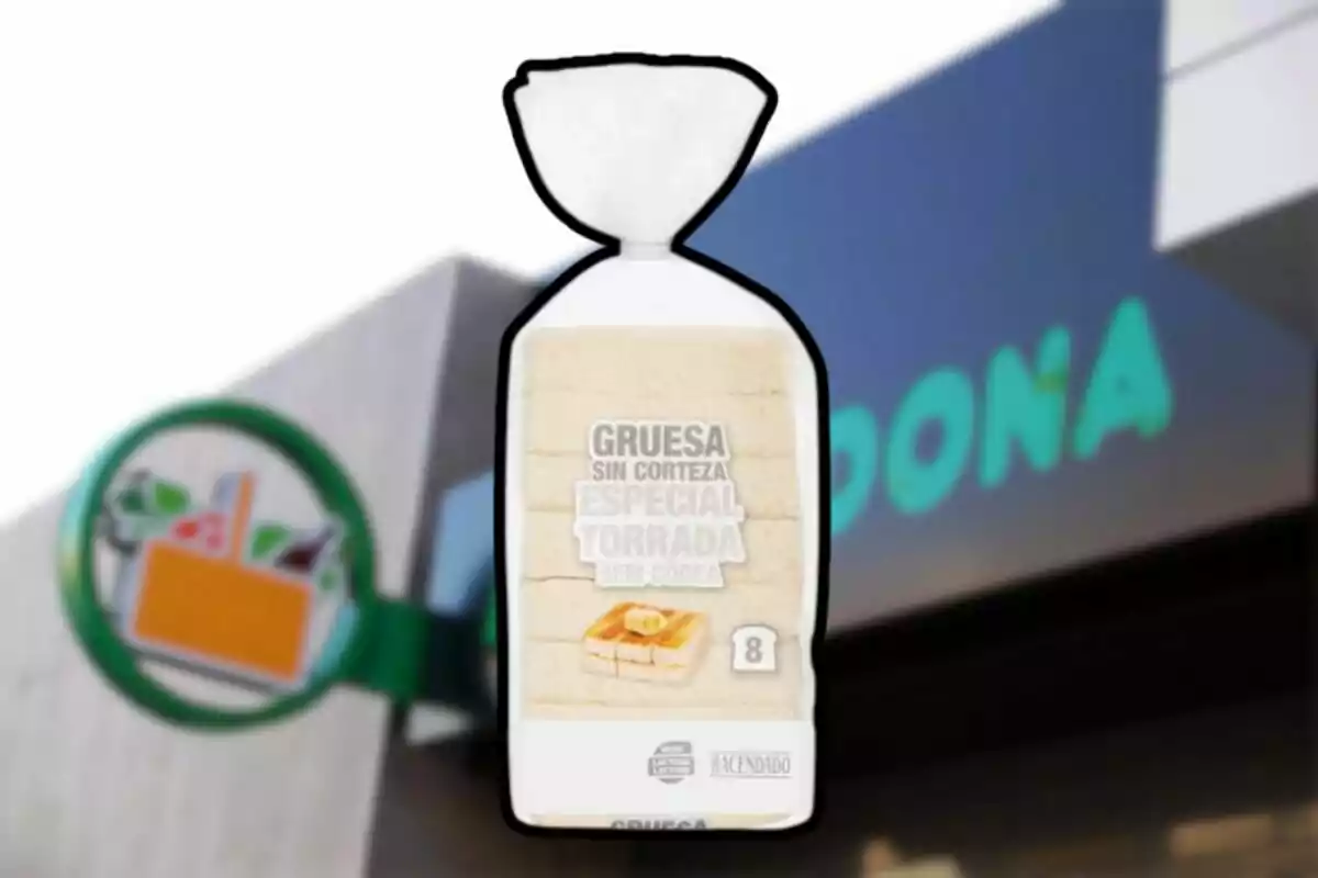 Paquete de pan de molde grueso sin corteza de la marca Hacendado frente a una tienda Mercadona desenfocada Paquete de pan de molde grueso sin corteza de la marca Hacendado frente a una tienda Mercadona desenfocada