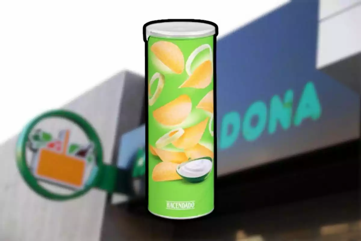 Envàs de patates fregides sabor crema i ceba de la marca Hacendado davant d’una botiga Mercadona desenfocada