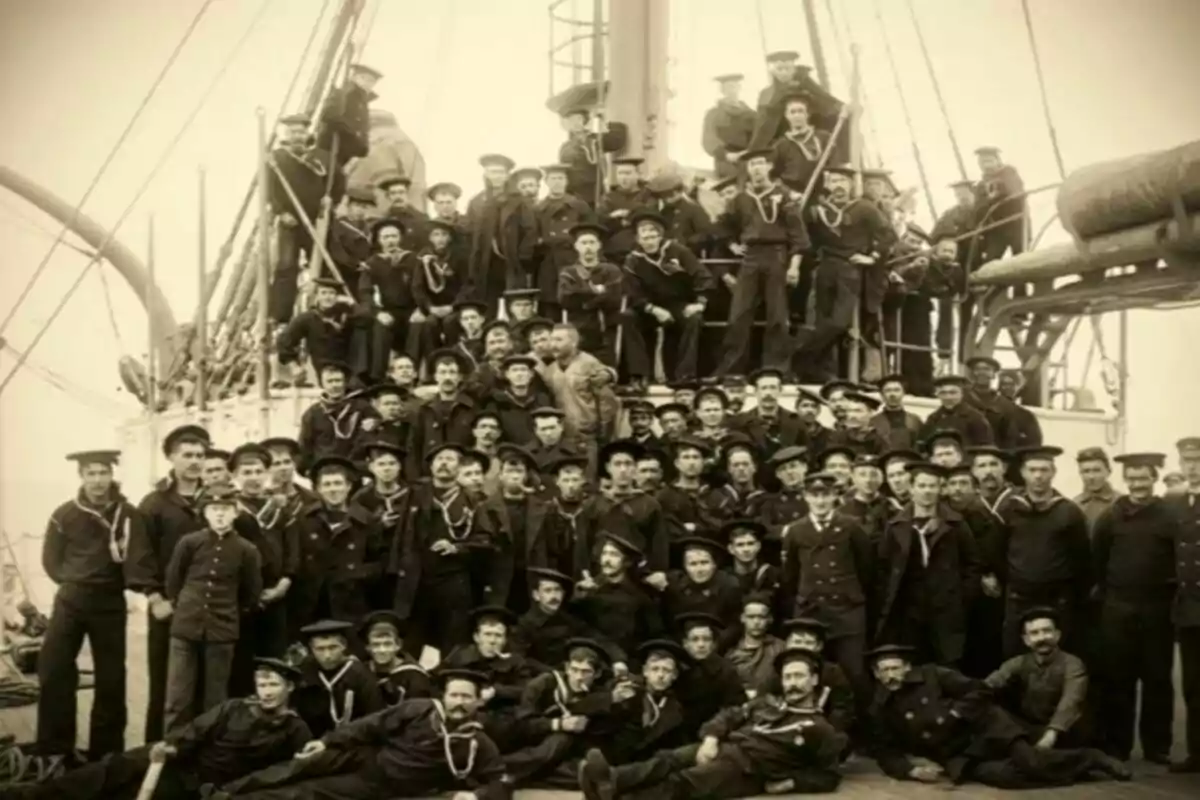 Gran grupo de marineros posando juntos en la cubierta de un barco antiguo Gran grupo de marineros posando juntos en la cubierta de un barco antiguo