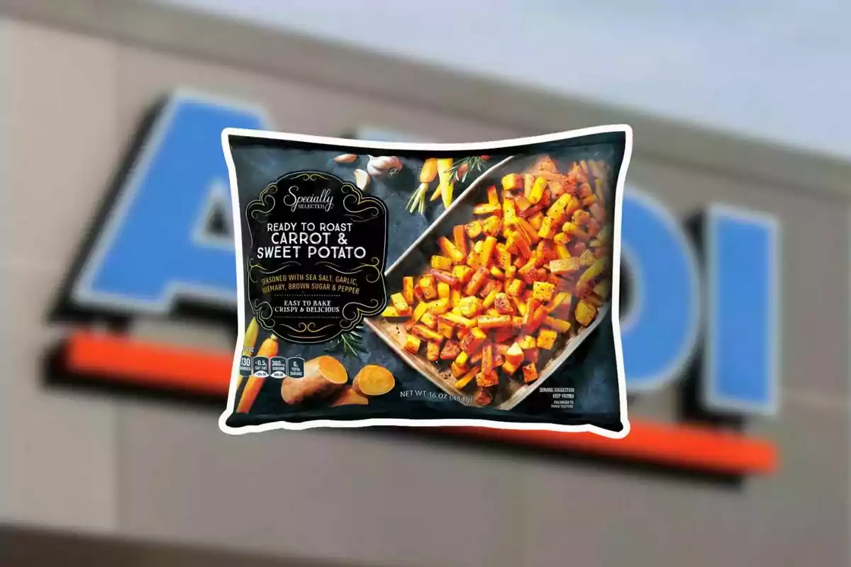 Bolsa de vegetales listos para asar de zanahoria y camote de la marca Specially Selected frente a un letrero borroso de Aldi Bolsa de vegetales listos para asar de zanahoria y camote de la marca Specially Selected frente a un letrero borroso de Aldi