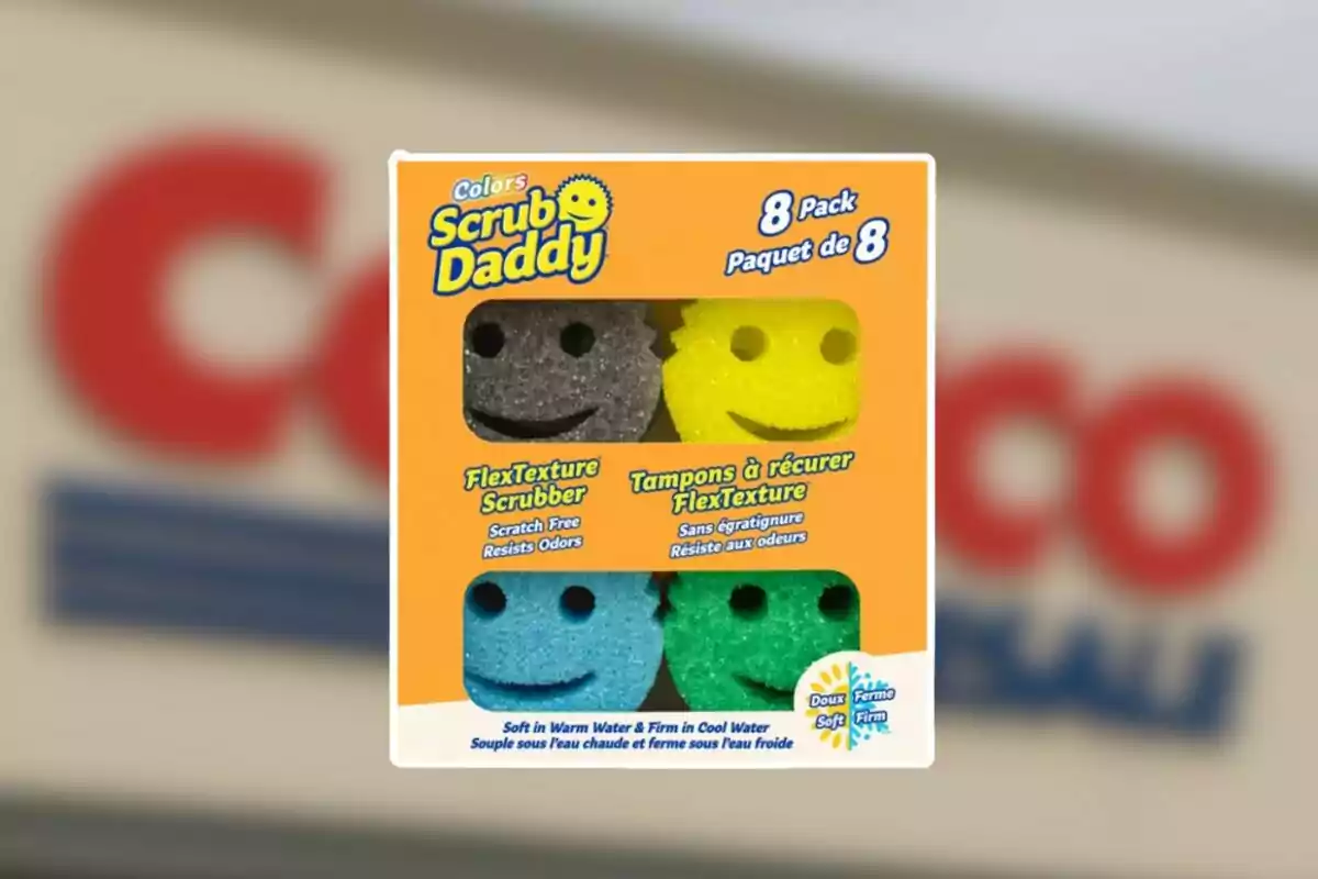 Paquete de ocho esponjas de colores Scrub Daddy con forma de carita sonriente en una caja naranja frente a un fondo borroso de una tienda Costco Paquete de ocho esponjas de colores Scrub Daddy con forma de carita sonriente en una caja naranja frente a un fondo borroso de una tienda Costco