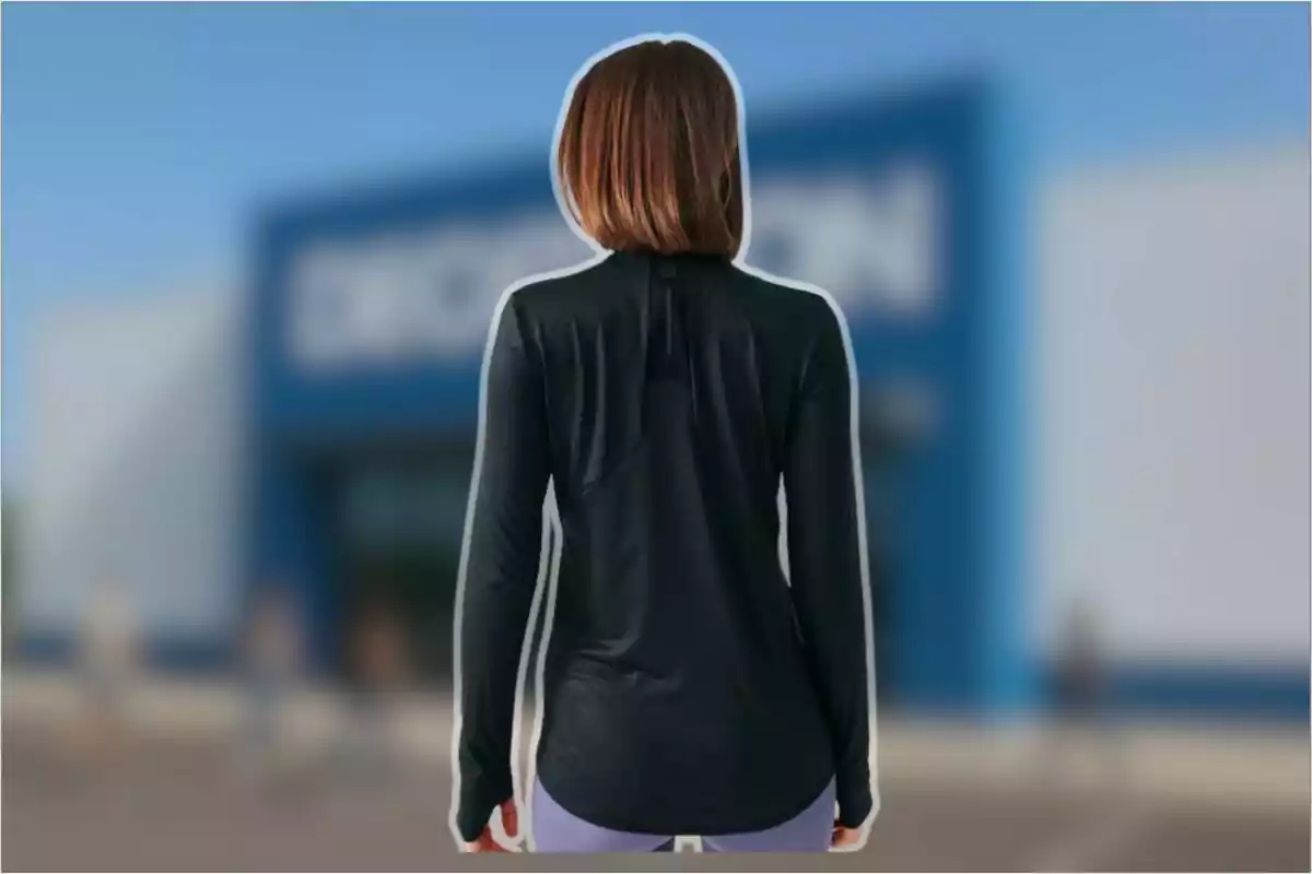 Persona d’esquena amb cabell curt i llis portant una samarreta negra de màniga llarga davant d’un edifici blau desenfocat Persona d’esquena amb cabell curt i llis portant una samarreta negra de màniga llarga davant d’un edifici blau desenfocat