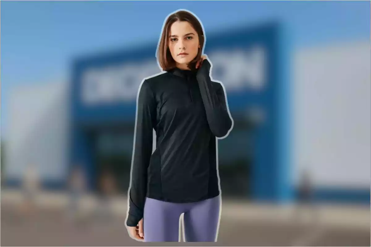 Dona jove amb cabell curt portant dessuadora negra i malles liles dreta davant d’una botiga amb façana blava desenfocada Dona jove amb cabell curt portant dessuadora negra i malles liles dreta davant d’una botiga amb façana blava desenfocada