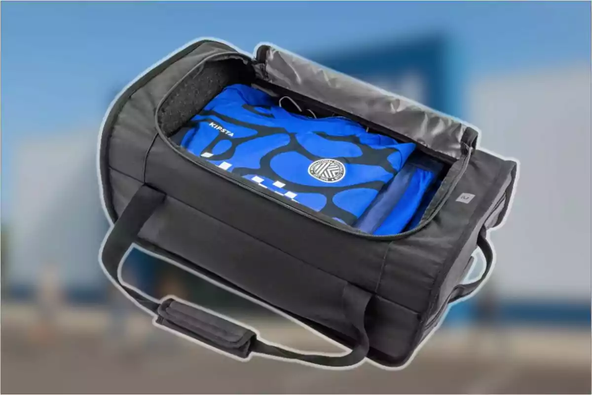 Bossa esportiva negra oberta mostrant un uniforme blau plegat a l’interior