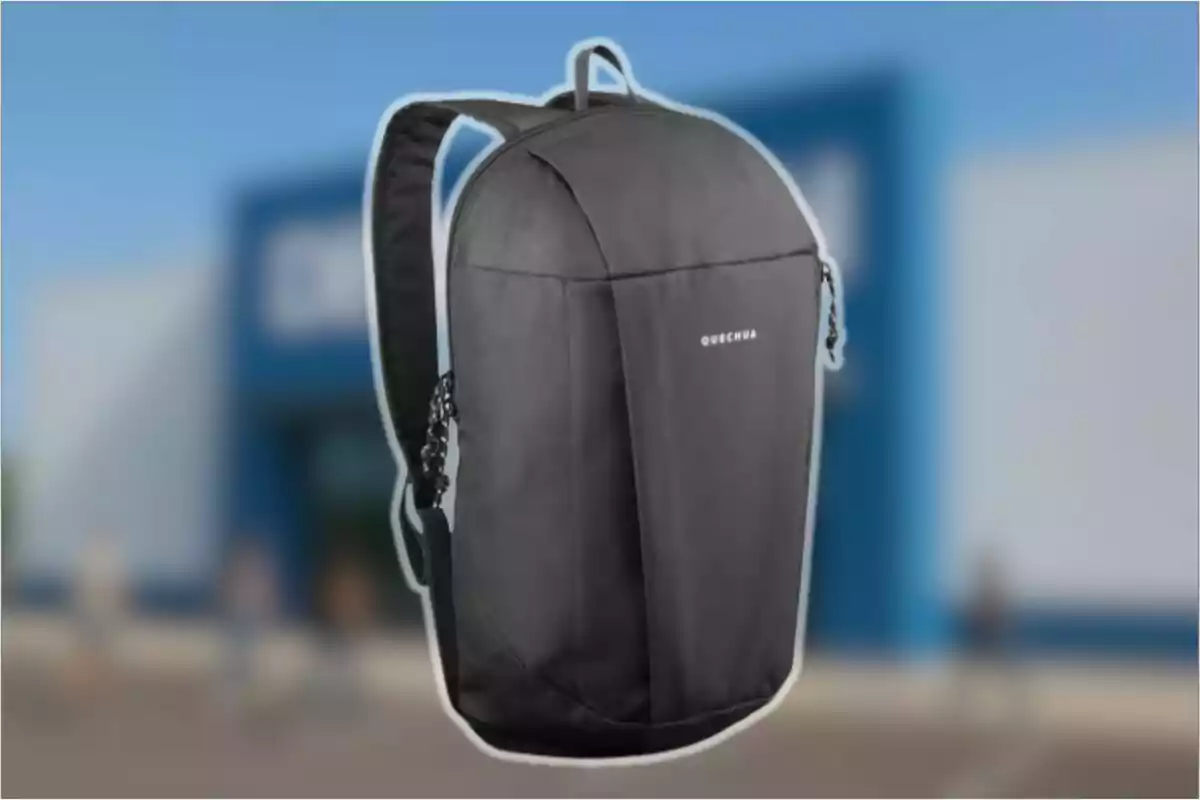 Motxilla negra Quechua amb tirants encoixinats sobre un fons desenfocat d’una botiga