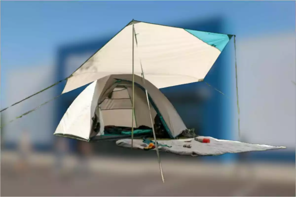 Tienda de campaña suspendida en el aire con una lona protectora y una colchoneta extendida al frente
