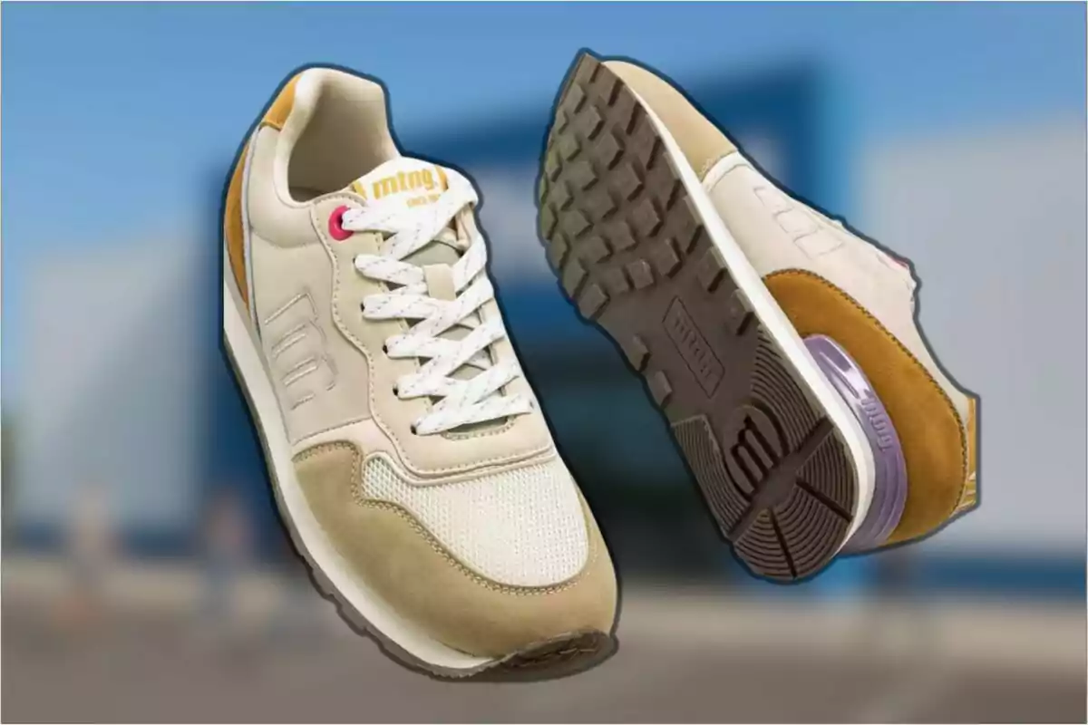 Un par de tenis deportivos beige con detalles en blanco y marrón flotando sobre un fondo desenfocado azul