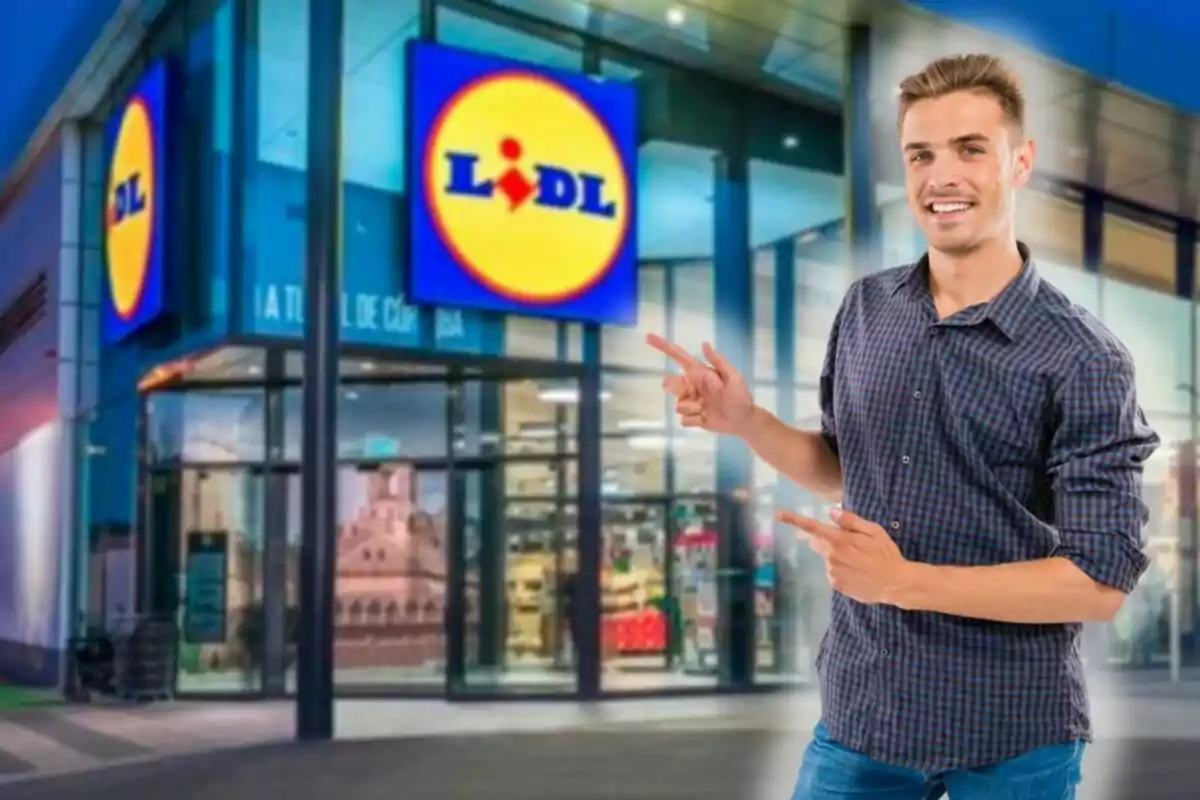 Home jove somrient assenyalant amb totes dues mans cap a l’entrada d’una botiga Lidl