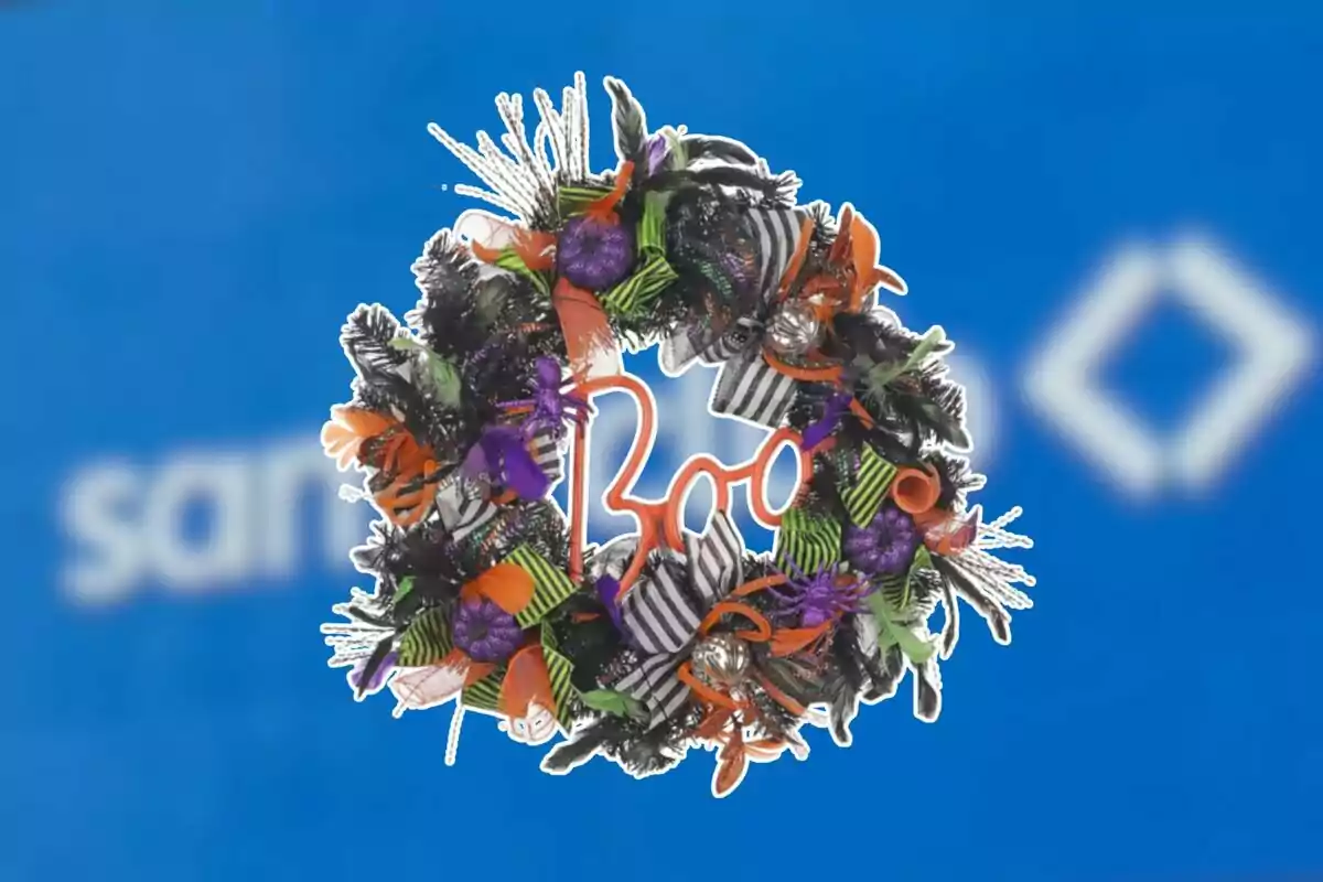 Corona decorativa de Halloween con la palabra Boo adornada con lazos naranjas, verdes, morados y listones a rayas sobre un fondo azul desenfocado Corona decorativa de Halloween con la palabra Boo adornada con lazos naranjas, verdes, morados y listones a rayas sobre un fondo azul desenfocado