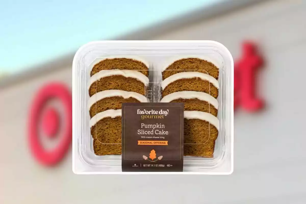 Rebanadas de pastel de calabaza con betún de queso crema en un envase de plástico transparente frente a una tienda