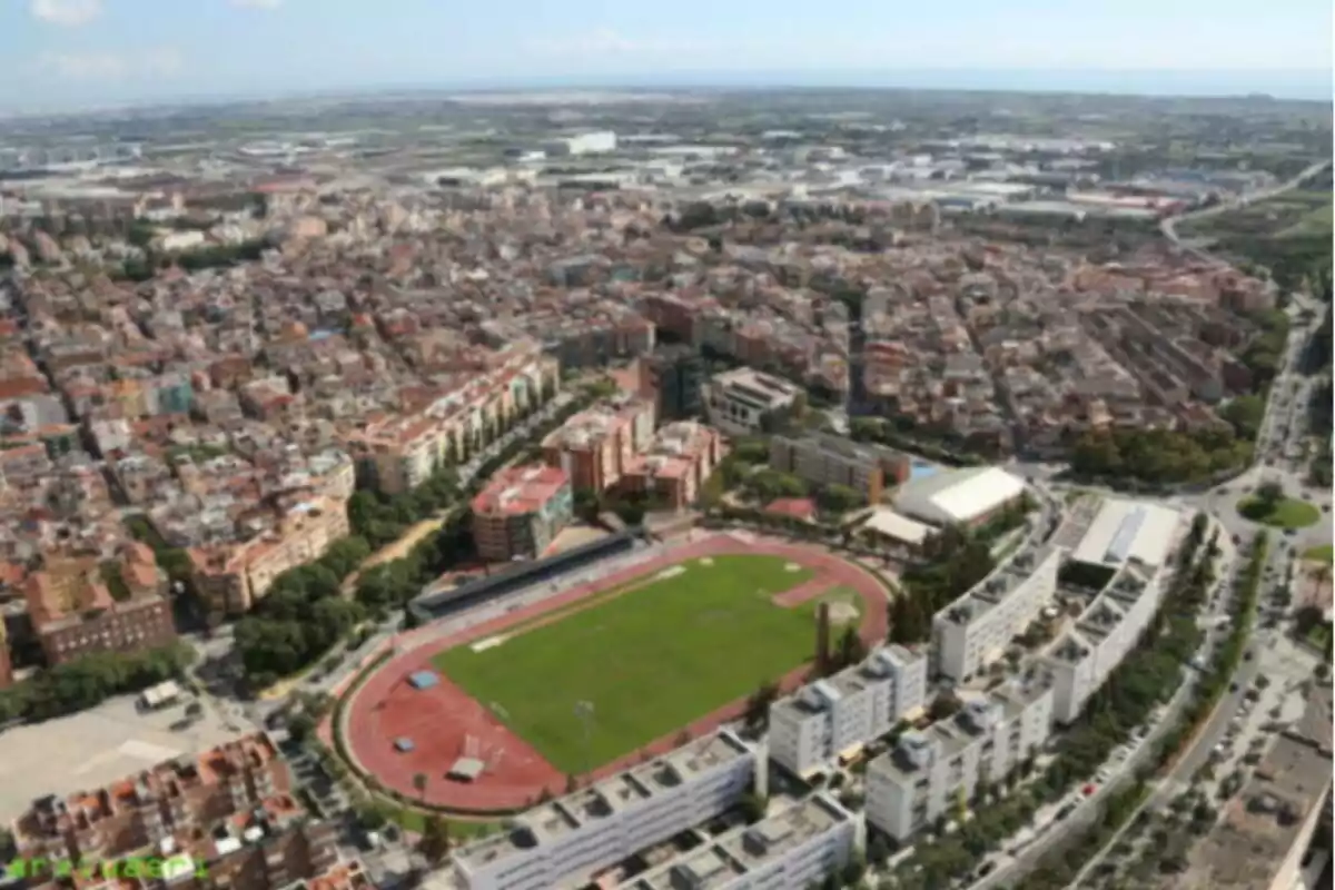Vista aèria d’una ciutat amb un estadi d’atletisme envoltat d’edificis i carrers Vista aèria d’una ciutat amb un estadi d’atletisme envoltat d’edificis i carrers