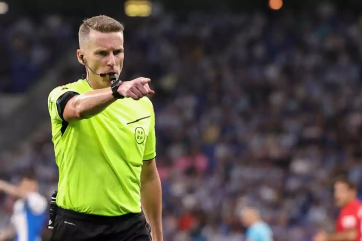 L’àrbitre de futbol Alejandro Hernández Hernández assenyalant amb el dit durant un partit en un estadi ple d’espectadors. L’àrbitre de futbol Alejandro Hernández Hernández assenyalant amb el dit durant un partit en un estadi ple d’espectadors.