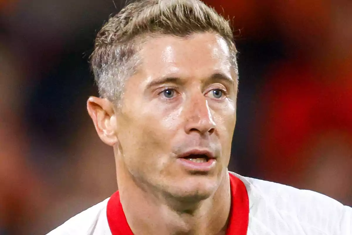 Close-up of Robert Lewandowski wearing a white jersey with red details during a match