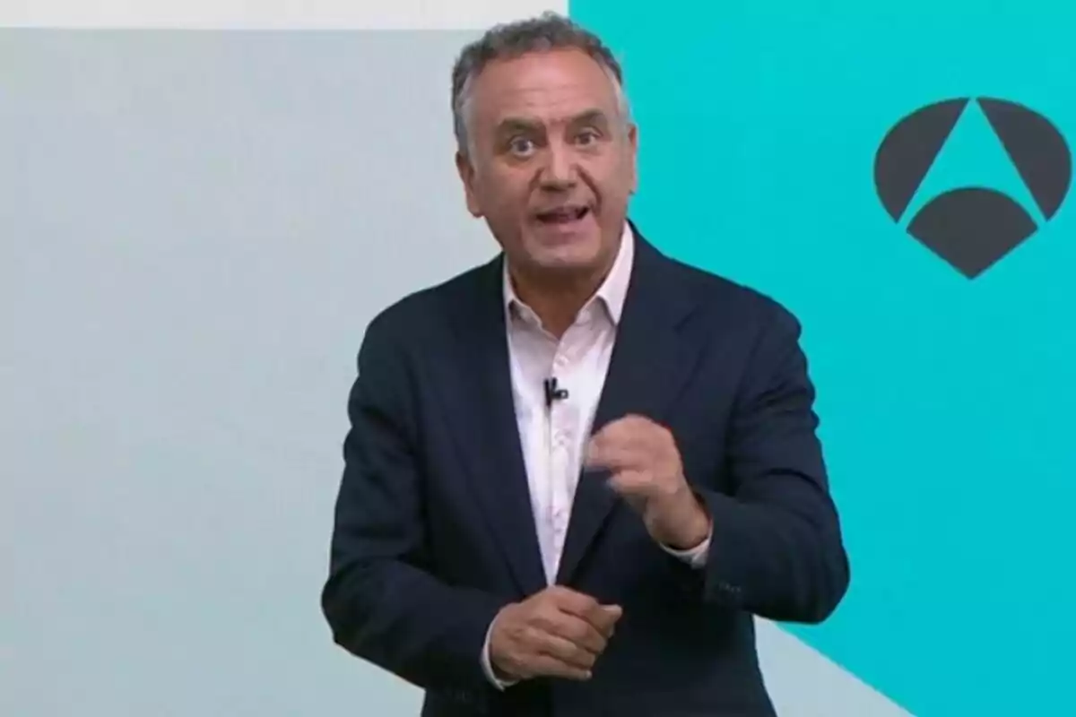 Pla mitjà de Roberto Brasero vestit amb un vestit fosc i camisa blanca parlant davant d’un fons blau amb un logotip geomètric, que és d’Antena 3. Pla mitjà de Roberto Brasero vestit amb un vestit fosc i camisa blanca parlant davant d’un fons blau amb un logotip geomètric, que és d’Antena 3.