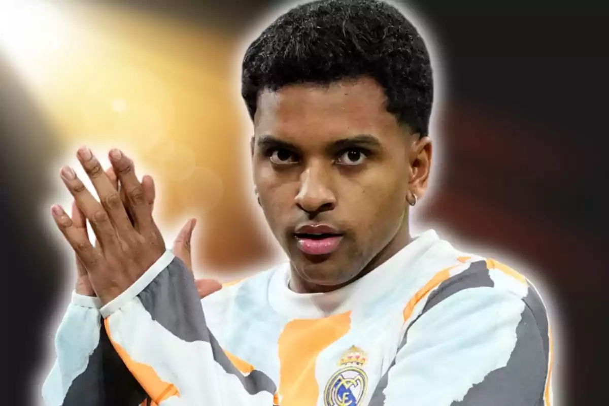 Futbolista con uniforme del Real Madrid aplaudiendo con fondo oscuro y luz brillante detrás